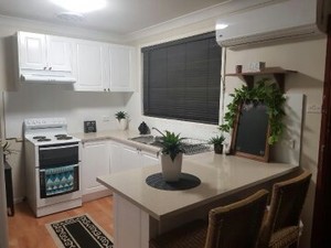 Ozy Unique Kitchens Pic 3 - Renovated medium sized kitchen with stone benchtops double sink stove and rangehood