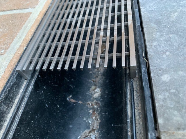 Everhard Industries Pic 1 - Shows how the stainless grates dont fit in the drain groove so they stick up and are loose TRIP HAZARD