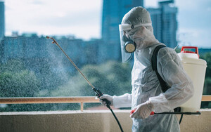 Trust Pest Control Melbourne Pic 3 - Oneman in protective suit spraying the house and disinfecting the housing exterminator pest control virus