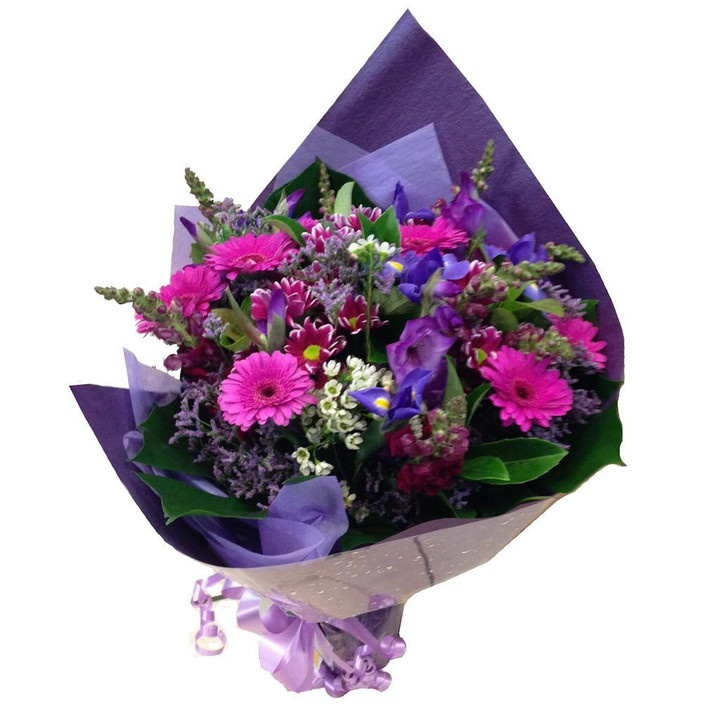 Wild Rose Florist Pic 1 - Mystique WRF84 A delightful bouquet of seasonal purple flowers in various shades arranged with selected foliage Presented in cellophane and coloured craft paper wrap with ribbons