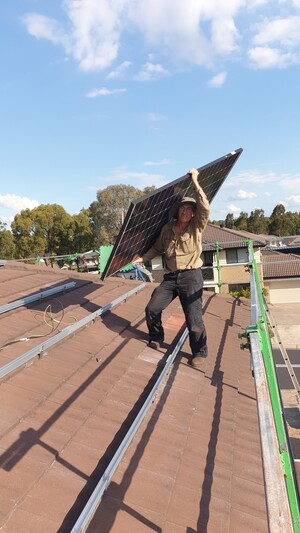 Western SYdney Solar Pty Ltd Pic 2 - Carrying a solar panel on a high roof