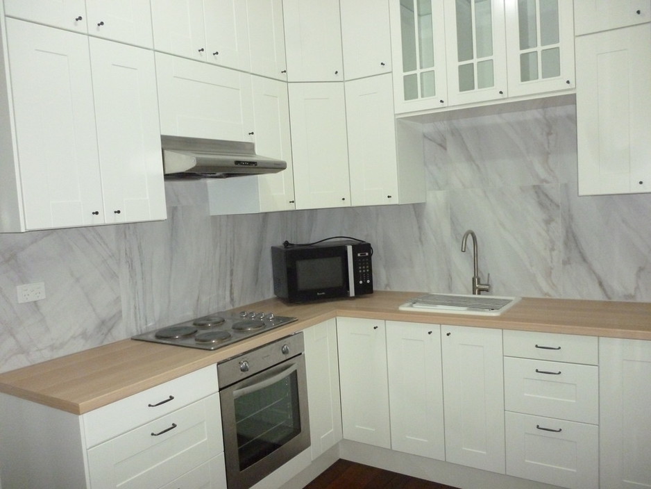 Paul Mather Pic 1 - In this 1940s unit the client wanted a wow factor kitchen on a budget The client choose to have cabinets going to the ceiling and used large tiles for the splash back