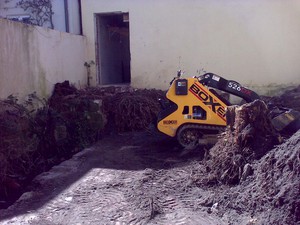 Boxxa Earthworx Pic 3 - small courtyard in woolarah sydney removal of existing trees and approx 40 cubic meters of soil entered through doorway just behind the machine