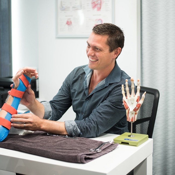 Active Hand Therapy Gold Coast Pic 1 - Hand Therapist David Coles providing a splint for a patient with an injured wrist at Active Hand Therapy