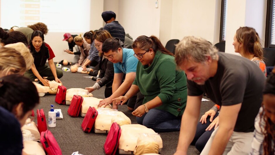 FirstAidPro Townsville Pic 1 - First aid teacher instructs students working on mannequin book firstaidpro Townsville qld