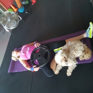 Fabulous Physiques Pic 2 - LeeAnn doing a Psoas stretch with a 20kg plate Lilly the pup supervising