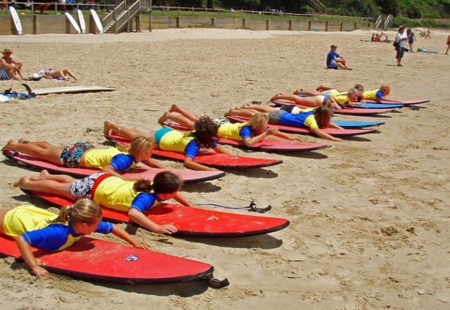 Port Macquarie Surf School Pic 2 - Girls go Surfing demonstrating how to paddle and stand up before they go for their learn to surf lesson