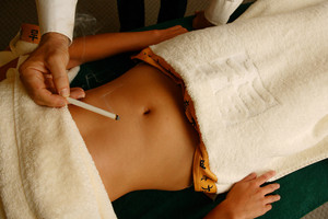 Paul McLeod Moxa Massage & Acupuncture Pic 5 - Stick moxa being applied to the abdomen to improve digestive function