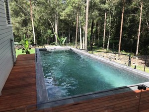 Bali Pools Pic 3 - Completed swimming pool by Bali Pools in Bonogin on the Gold Coast Complete with coping and decking surrounds Also included is frameless glass fencing to maintain the great views