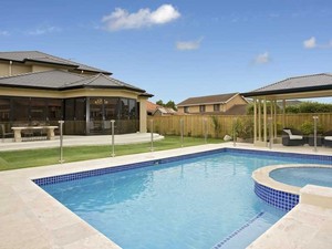 Bali Pools Pic 4 - Pebble interior pool completed by Bali Pools leading Gold Coast concrete pool builders Spa addition to allow for relaxation Also included is blue waterline tiles large coping and frameless glass fencing for uninterrupted views