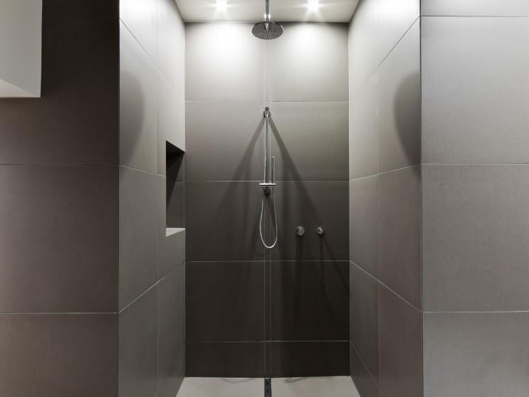 Matzco Tiling Pic 1 - Shower channel grate runs the full length of the bathroom through the centre with the bath on the opposite wall to the entry Cut tiles in the centre of the wall match the grate