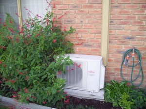 Fairbairns Heating & Cooling Pty Ltd Pic 5 - Outdoor unit of Split System Air Conditioner installed on concrete slab in garden bed